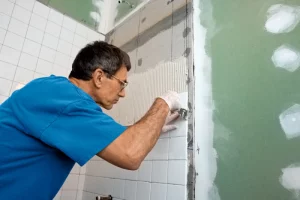 Un homme faisant des travaux de construction dans la salle de bain
