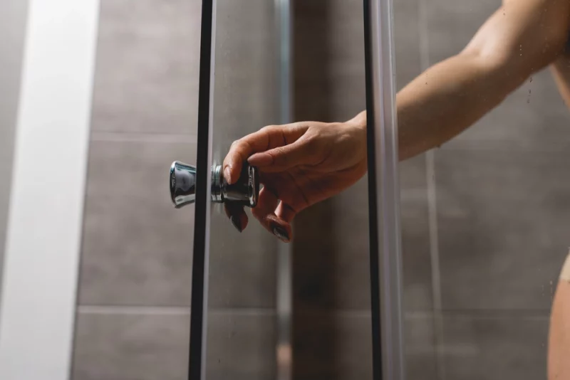 Une femme ouvrant une porte de douche
